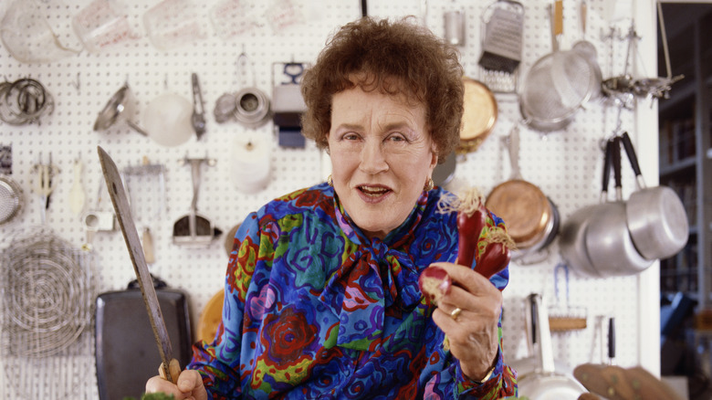 Close-up of Julia Child holding a knife and some peppers