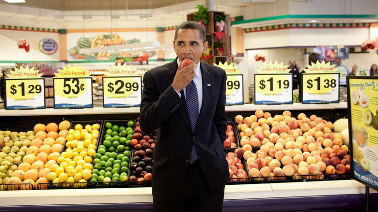 President Obama eats a peach in a grocery store produce aisle