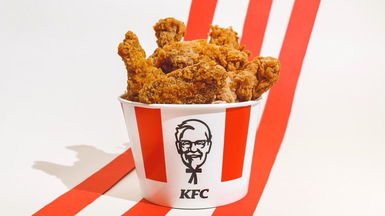Bucket of KFC chicken on white background with three red stripes