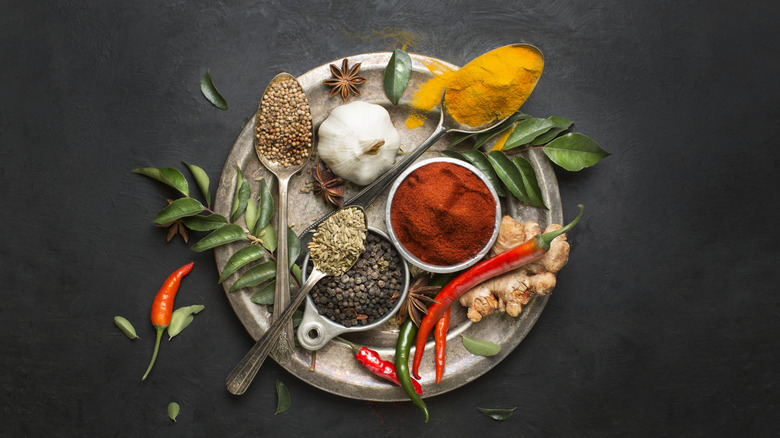 overhead shot of a platter of spices and seasoning that make up both Thai and Indian curry sauces