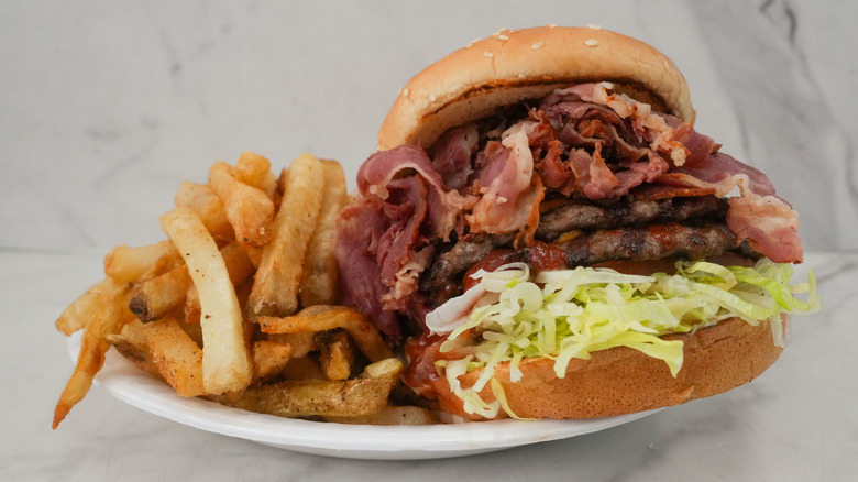 Pastrami burger on plate with fries