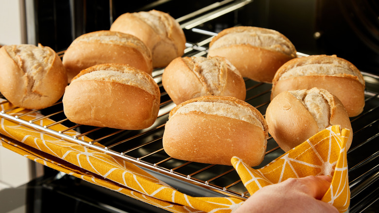 Removing fresh baked rolls from the oven