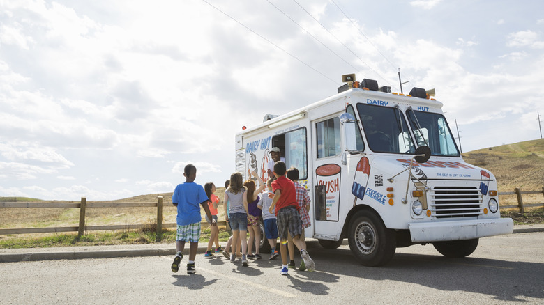 Children waiting outside the window of an ice cream truck