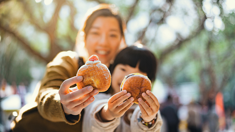 A mother and daughter eating donuts