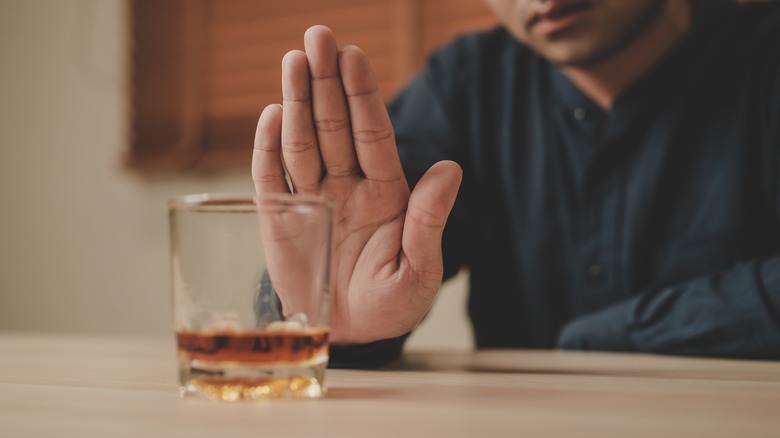 Person with a hand up, refusing alcohol