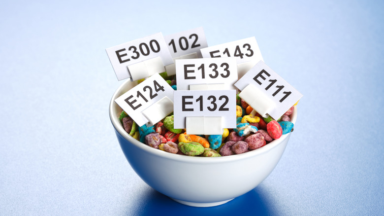 A bowl of candy with several food additive labels