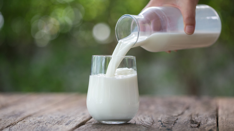 Milk being poured from jug into glass